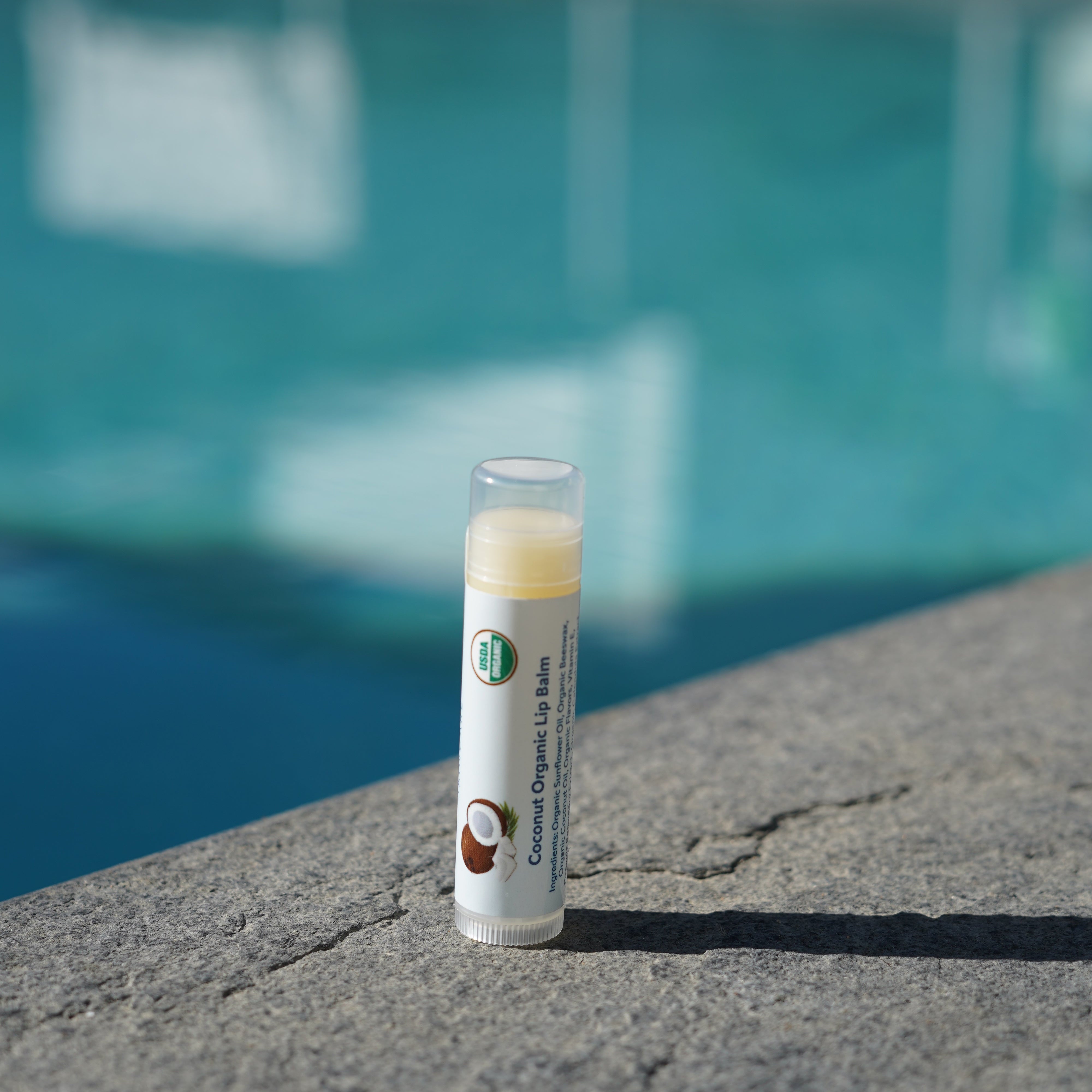 Lip balm tube on a stone surface with a blurred background