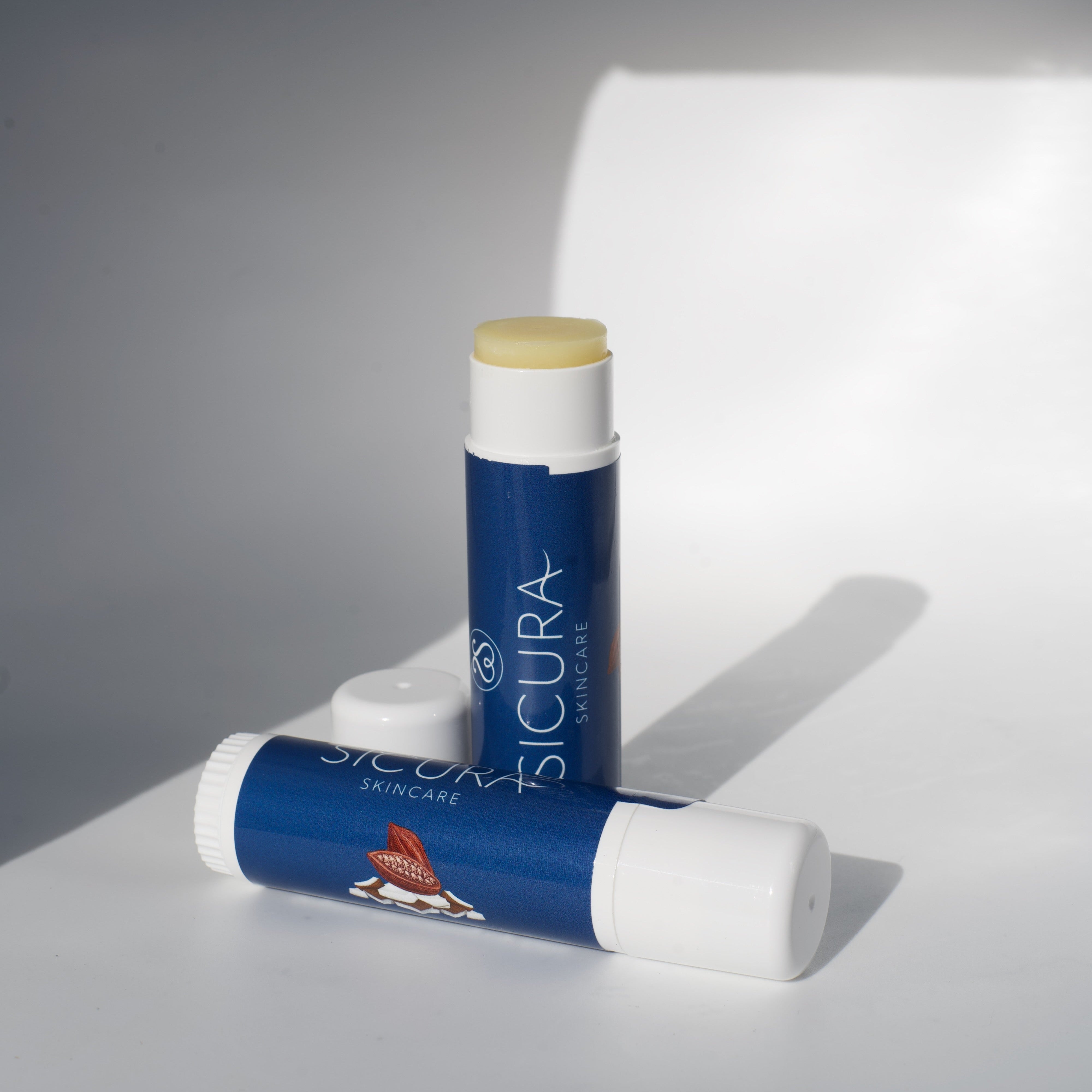 Two organic body balm products with visible branding on a gray background