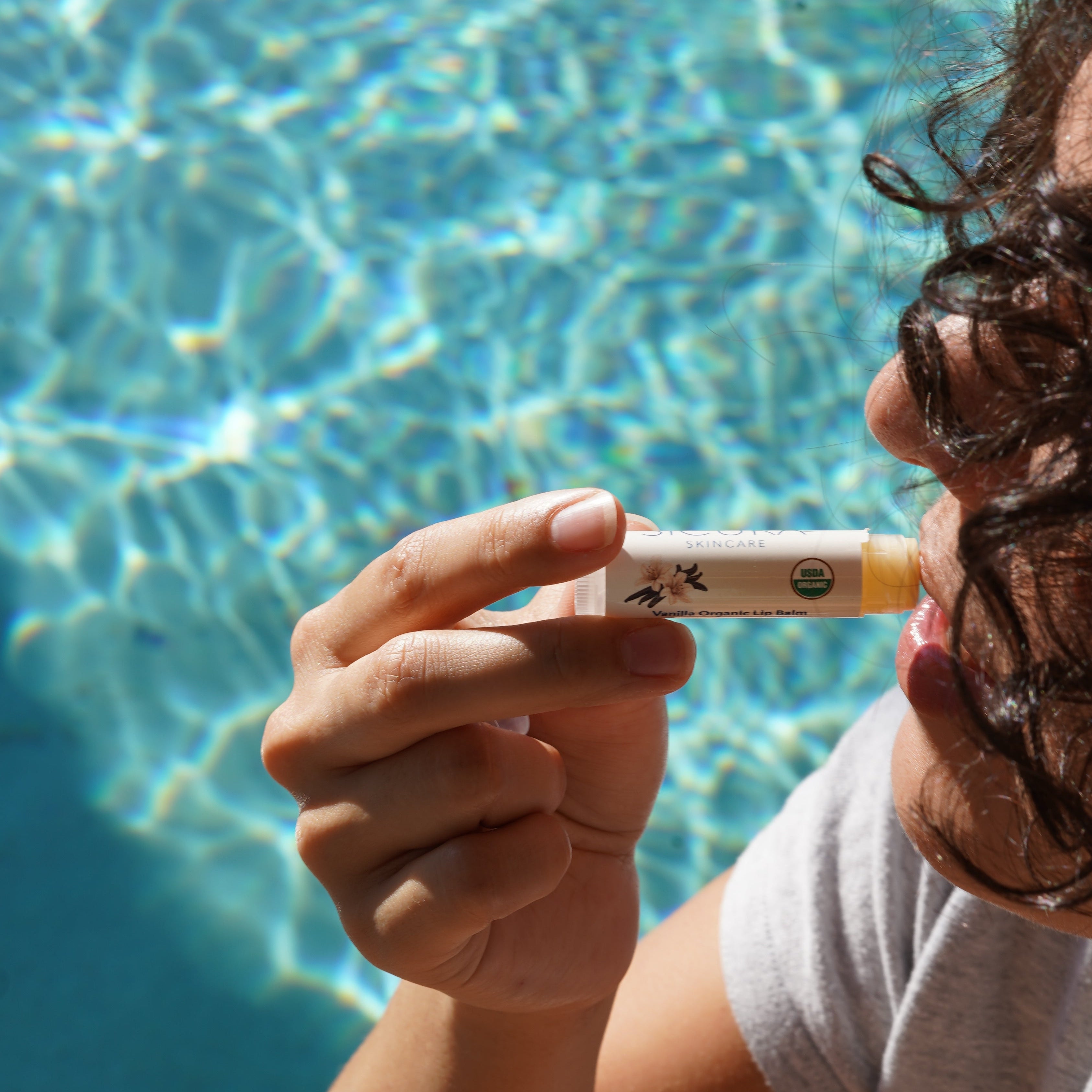 Person holding a small object near a pool